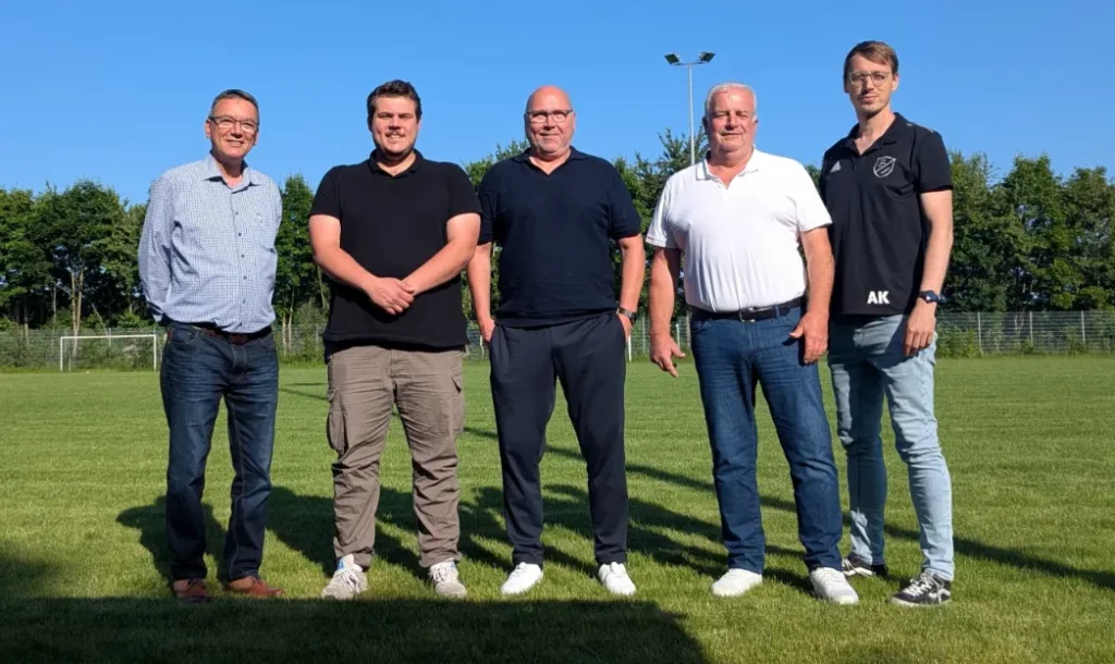 Fünf Männer stehen auf einem Fußballfeld während des Trainings