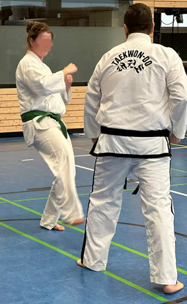 Mann und Frau im Dobok trainieren gemeinsam unter der Anleitung des VfL Brohl in einer Taekwondo-Stunde